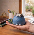 Chunky Blue Cat Figurine with Striped Spiral Tail, held in a hand for scale