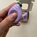 Glazed Clay Eggplant Worry Stone Keychain, held in a hand for scale