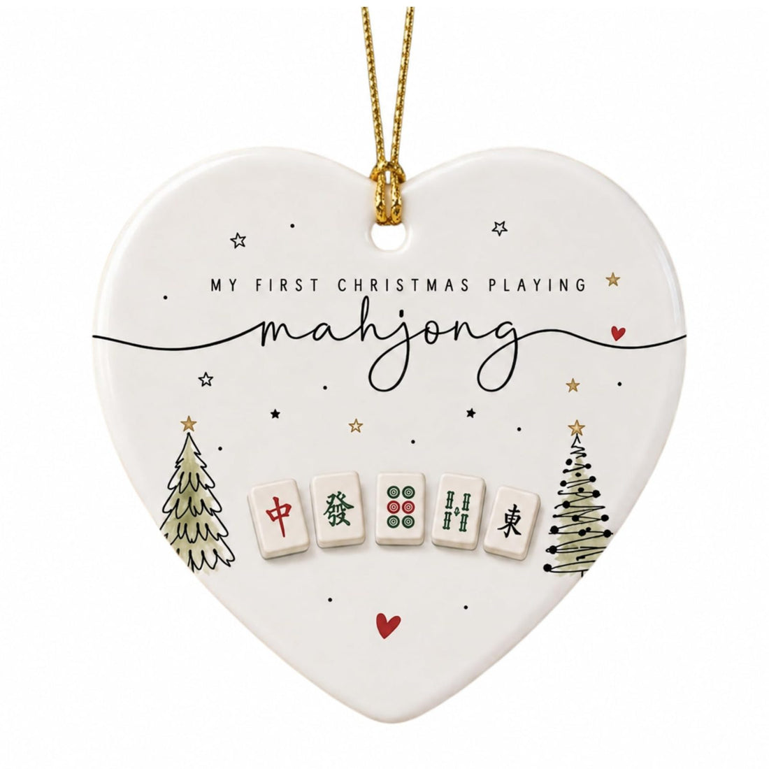 White heart-shaped ceramic ornament with two small Christmas trees, mahjong tiles and the words My First Christmas Playing mahjong