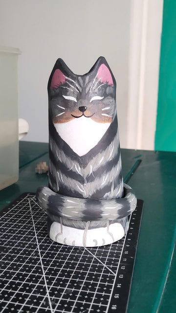 A painted clay cat vase in progress on the workbench